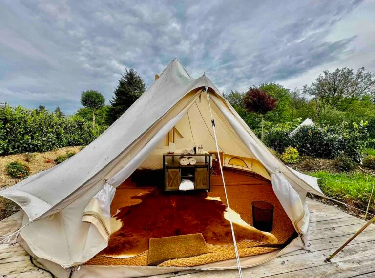 Intérieur chaleureux d’une tente de glamping au Domaine de Bra