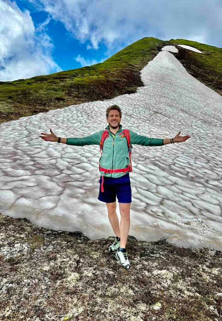 Randonneur devant un névé sur les hauteurs de Nendaz
