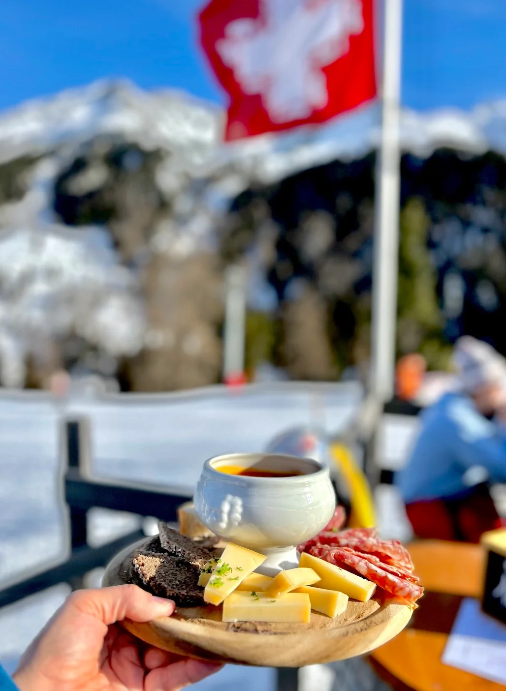 Assiette valaisanne et fondue sur une terrasse enneigée