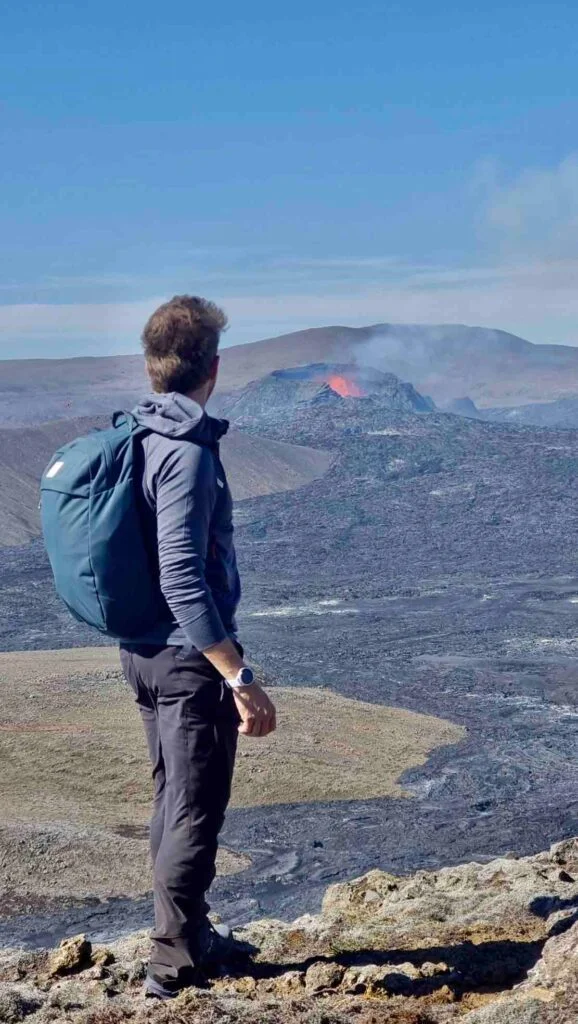 Randonneur observant un cratère volcanique actif dans la péninsule de Reykjanes en Islande