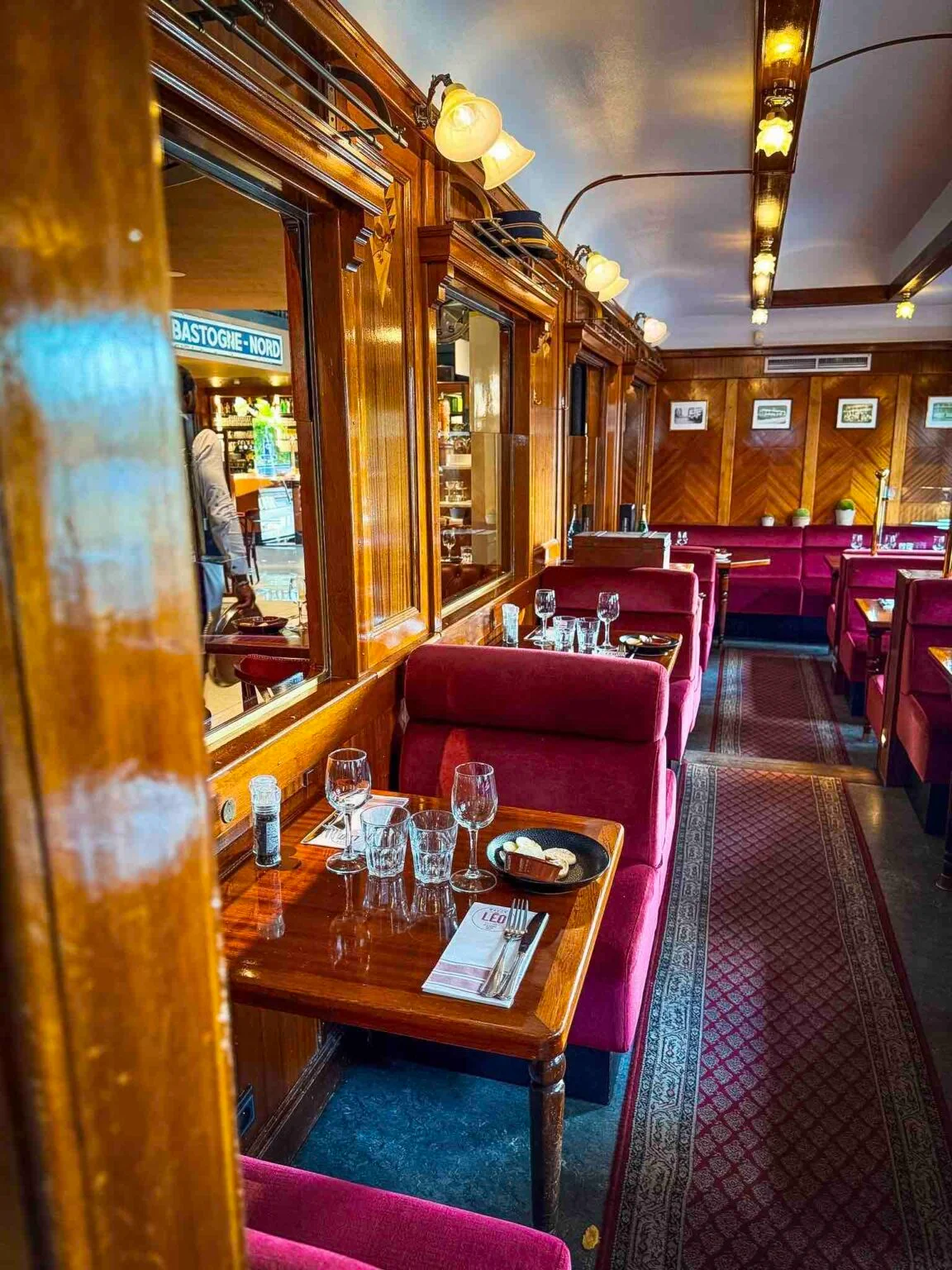 Cabine en bois et banquettes rouges dans le restaurant Wagon Léo
