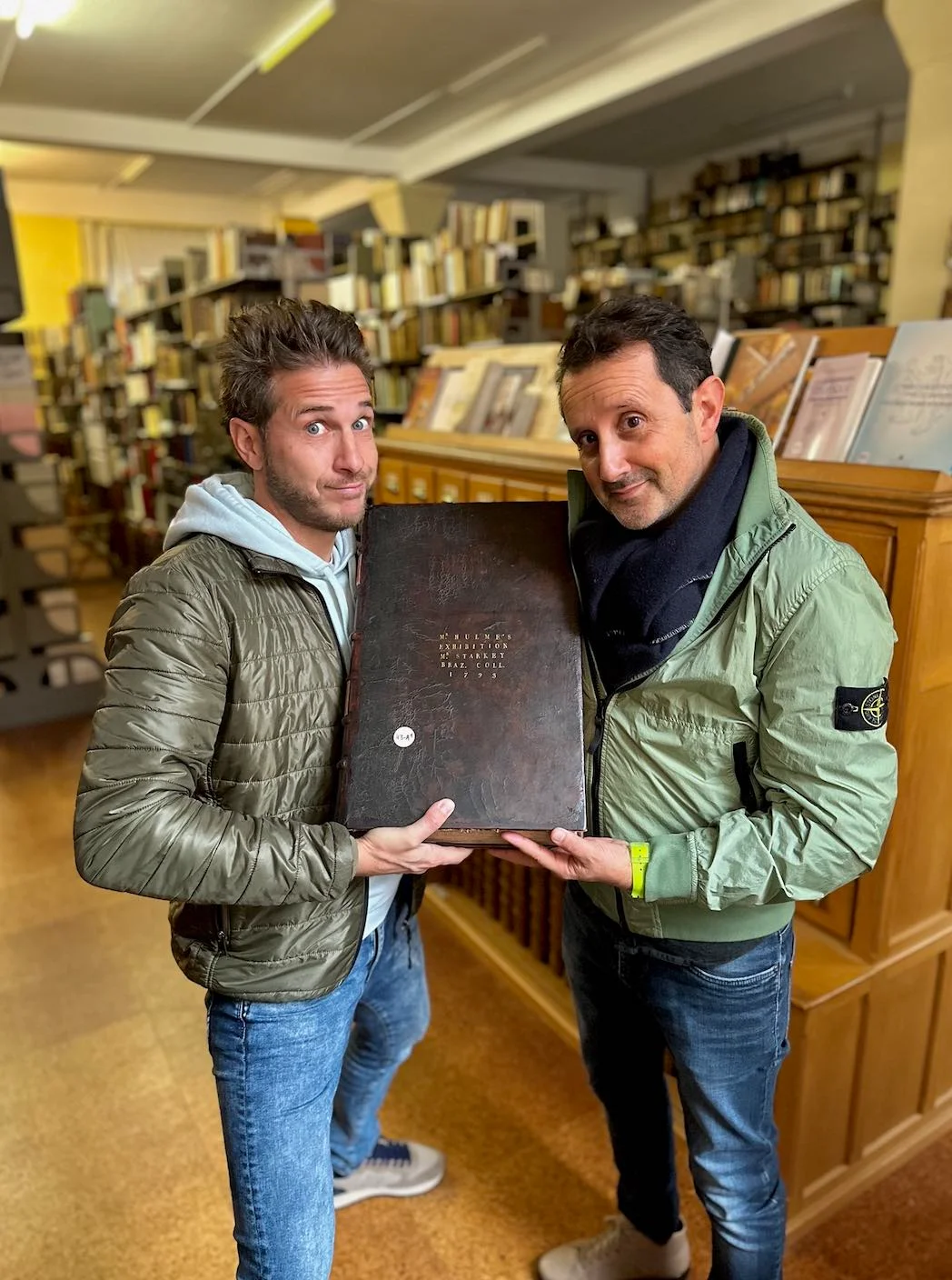 Visiteurs consultant un ouvrage ancien dans une bibliothèque de Clervaux