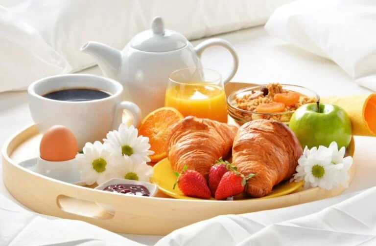 Plateau de petit-déjeuner avec croissants, fruits et boissons chaudes
