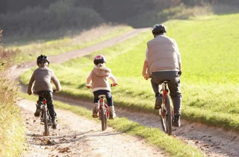 Famille à vélo sur un chemin de campagne dans la vallée de la Molignée