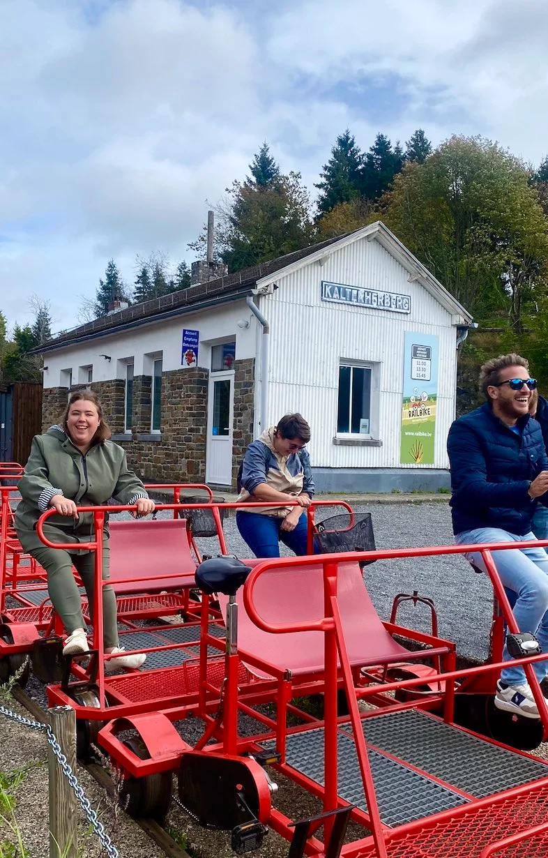 Voyageurs installés sur des draisines rouges au départ du railbike de Leykaul