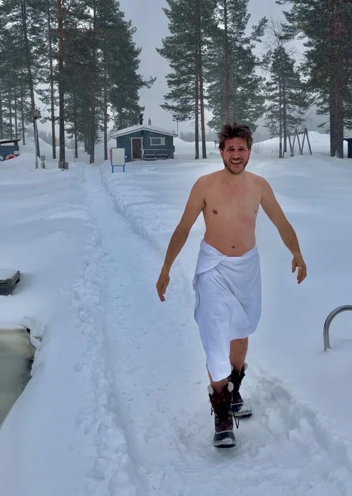 Voyageur sortant du sauna dans la neige en Laponie finlandaise