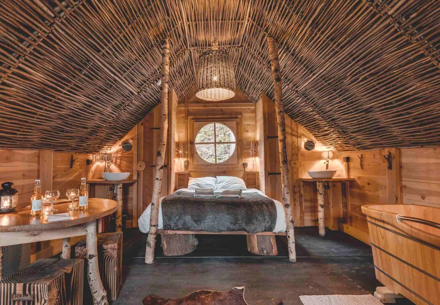 Chambre en bois avec lit à baldaquin de bouleaux et baignoire