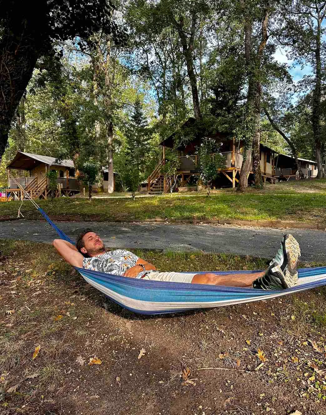 Voyageur se reposant dans un hamac devant les hébergements du camping