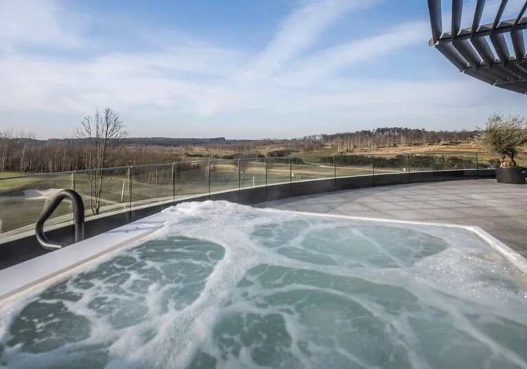 Bain à remous extérieur du spa Cinq Mondes face au golf du Bois d’Arlon